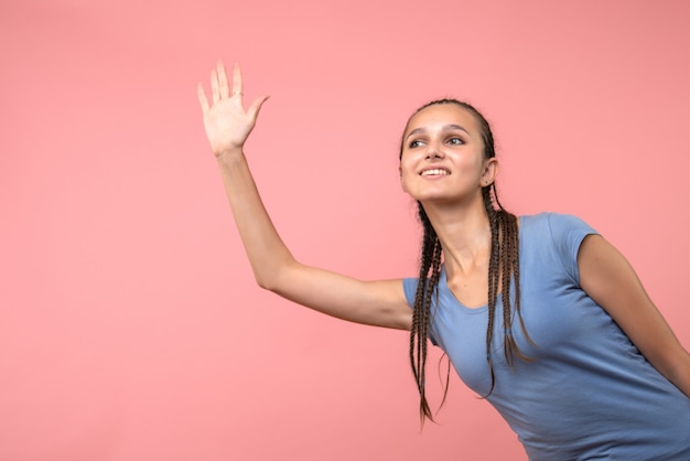 Vista frontale della giovane donna salutando qualcuno in rosa