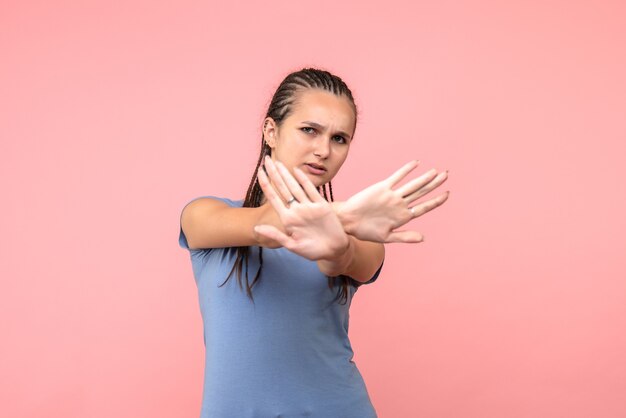 Vista frontale della giovane donna scontenta sul rosa