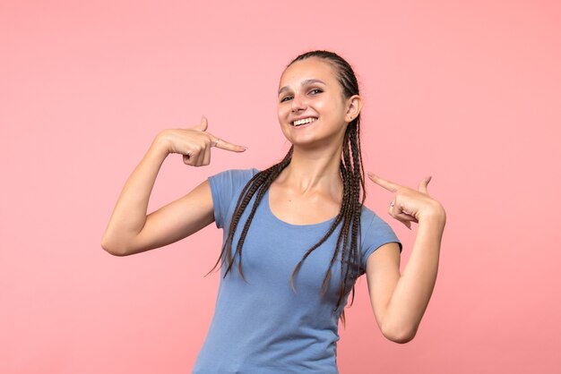 Vista frontale della giovane donna sorridente sul rosa