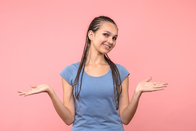 Vista frontale della giovane donna sorridente sul rosa