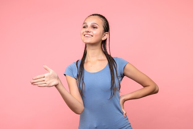 Vista frontale della giovane donna sorridente sul rosa