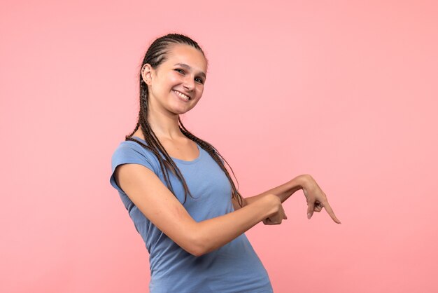 Vista frontale della giovane donna sorridente sul rosa