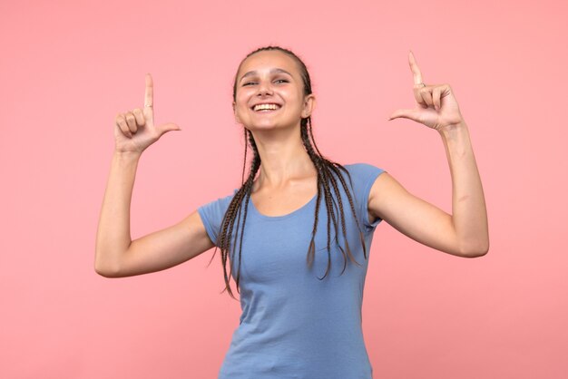 Vista frontale della giovane donna sorridente sul rosa