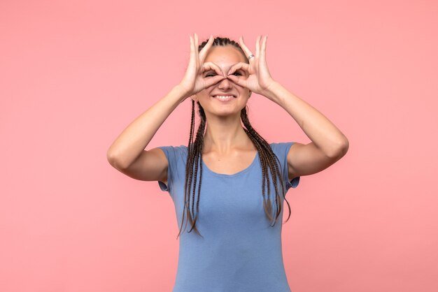 Vista frontale della giovane donna sorridente sul rosa