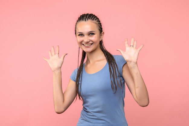 Vista frontale della giovane donna sorridente sul rosa