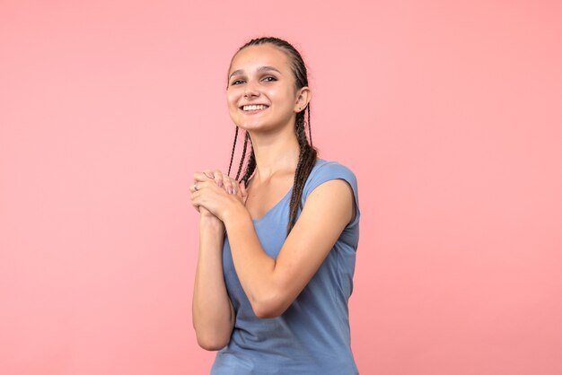 Vista frontale della giovane donna sorridente sul rosa