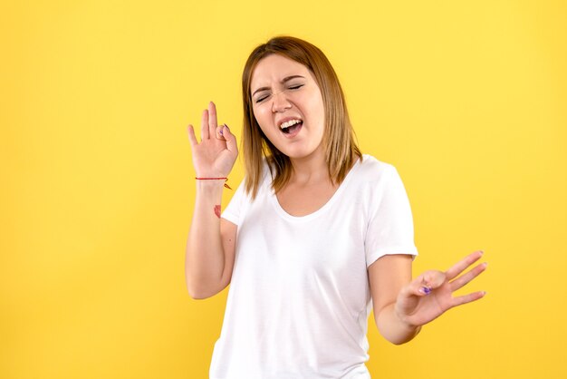 Vista frontale della giovane donna sulla parete gialla