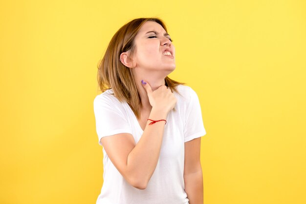 Vista frontale della giovane donna sulla parete gialla