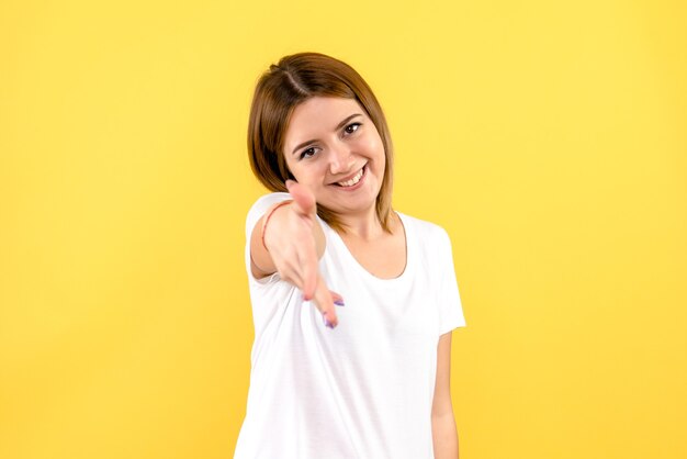 Vista frontale della giovane donna sulla parete gialla