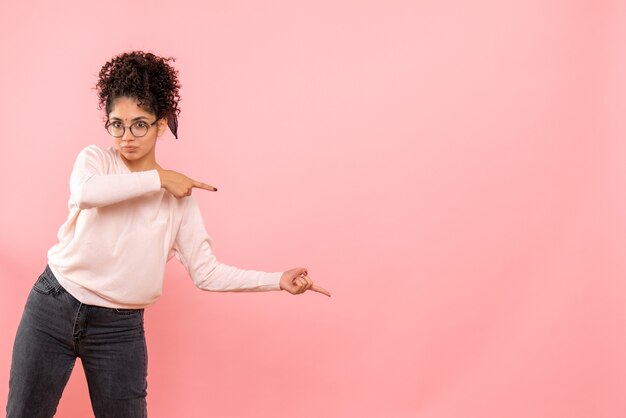 Vista frontale della giovane donna sulla parete rosa