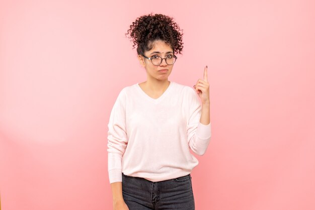 Vista frontale della giovane donna sulla parete rosa