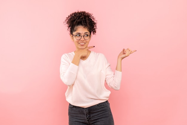 Vista frontale della giovane donna sulla parete rosa