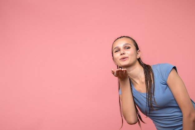 Vista frontale della giovane femmina che invia baci d'aria sul rosa