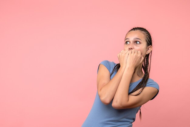 Vista frontale della giovane femmina nervosa sul modello rosa emozione della ragazza dei capelli della gioventù