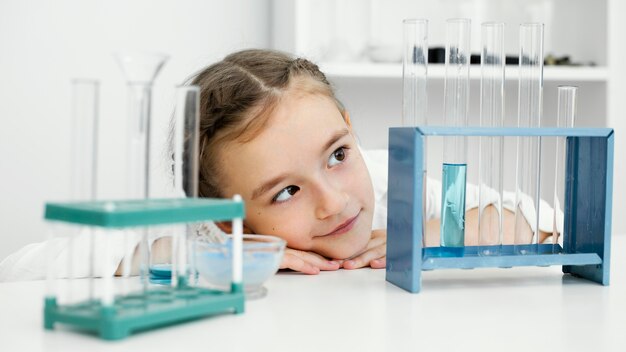 Vista frontale della giovane ragazza scienziato con provette in laboratorio