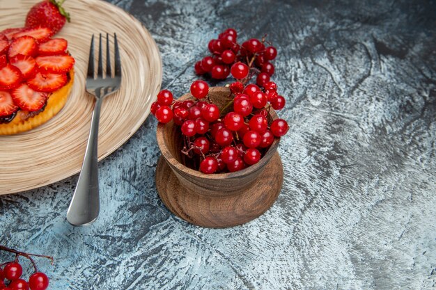 Vista frontale della gustosa torta di fragole con frutti di bosco sulla superficie scura