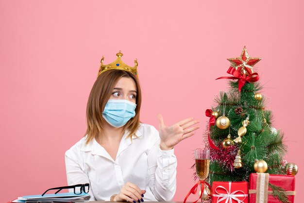 Vista frontale della lavoratrice in maschera sterile con corona in rosa