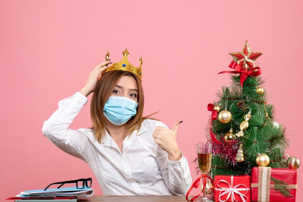 Vista frontale della lavoratrice in maschera sterile con corona in rosa