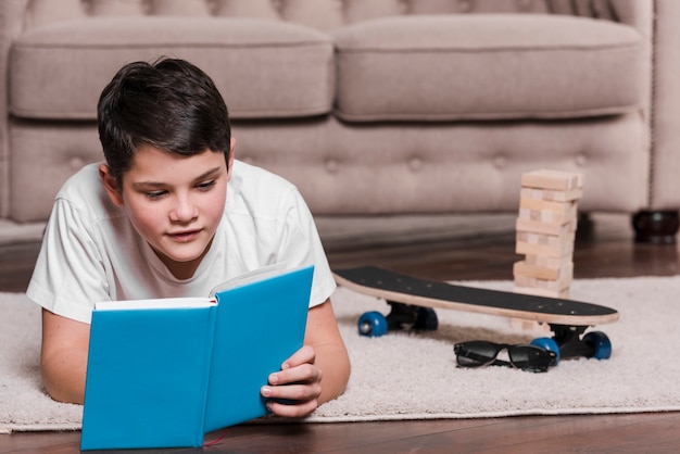 Vista frontale della lettura del ragazzo da un libro