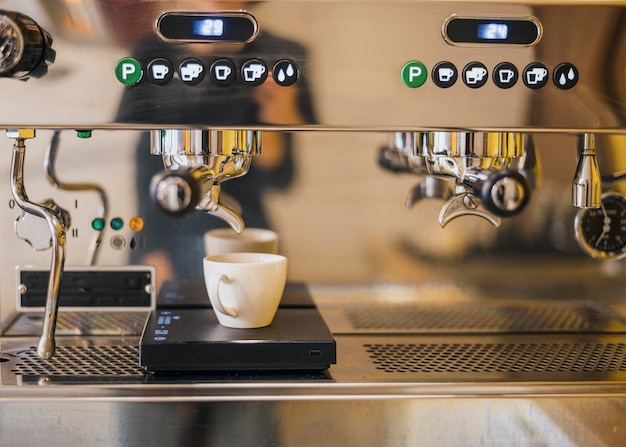 Vista frontale della macchina per il caffè con la tazza