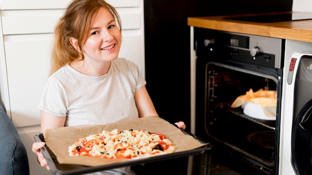 Vista frontale della madre che cucina a casa