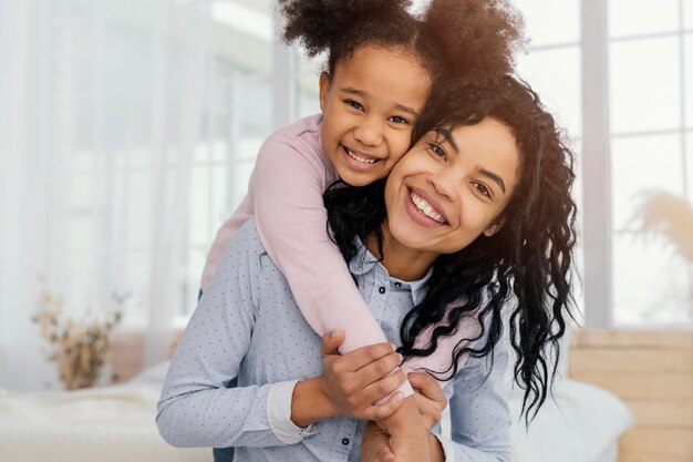 Vista frontale della madre che gioca in casa con sua figlia