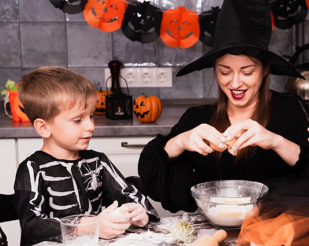 Vista frontale della madre e del figlio che producono i biscotti