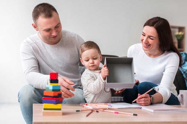 Vista frontale della madre e del padre con il bambino a casa