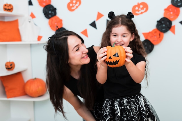 Vista frontale della madre e della figlia con la zucca