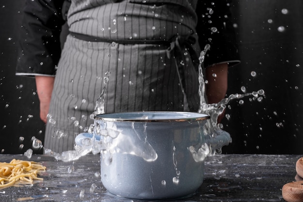 Vista frontale della pentola con acqua e chef