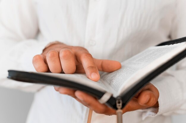 Vista frontale della persona che legge dal libro sacro