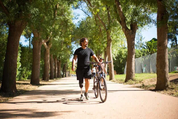 Vista frontale della persona con disabilità con bicicletta