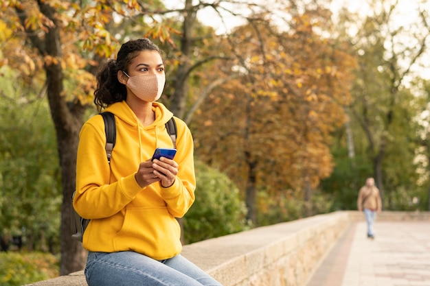 Vista frontale della ragazza con la maschera per il viso sulla strada