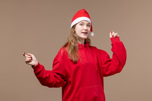 Vista frontale della ragazza di natale che balla su sfondo marrone donna vacanza Natale