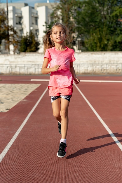 Vista frontale della ragazza in t-shirt rosa in esecuzione