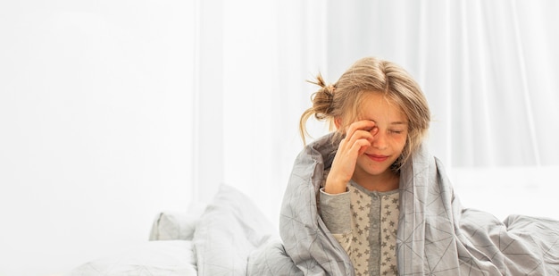 Vista frontale della ragazza sorridente a letto