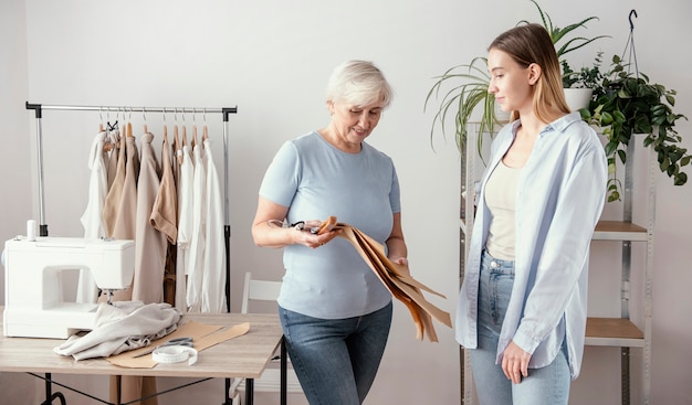 Vista frontale della sarta femminile in studio con il cliente