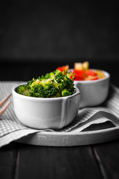 Vista frontale della tazza di broccoli sul piatto con un panno