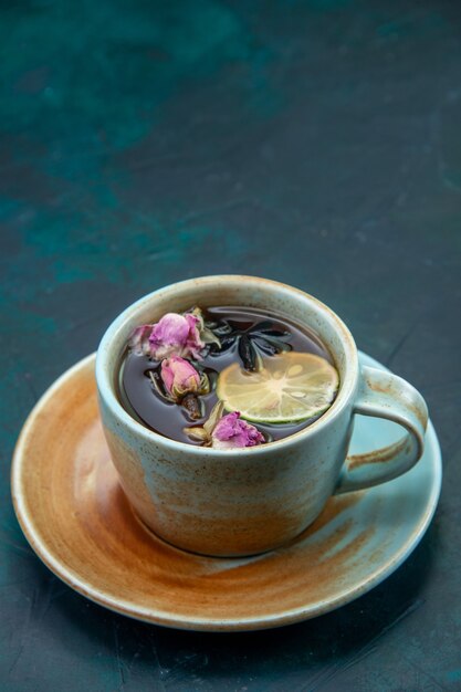 Vista frontale della tazza di tè con limone e fiori
