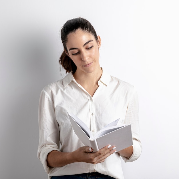 Vista frontale della tenuta della donna e del libro di lettura