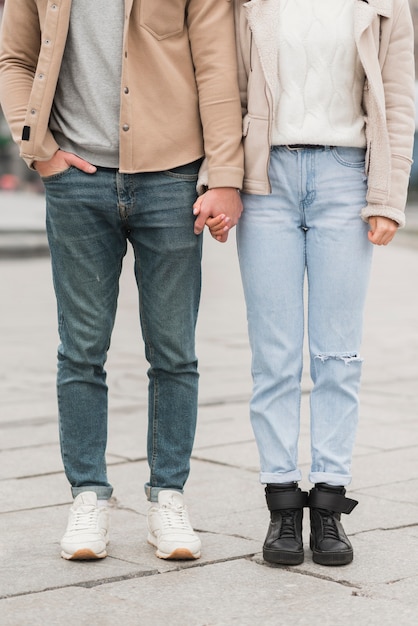 Vista frontale delle coppie che posano mentre tenendosi per mano