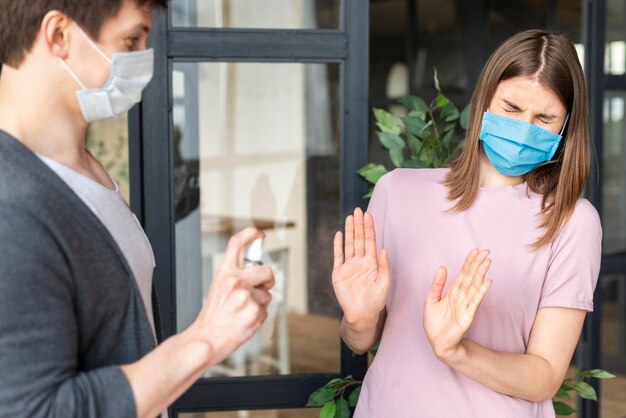 Vista frontale delle coppie facendo uso della maschera medica