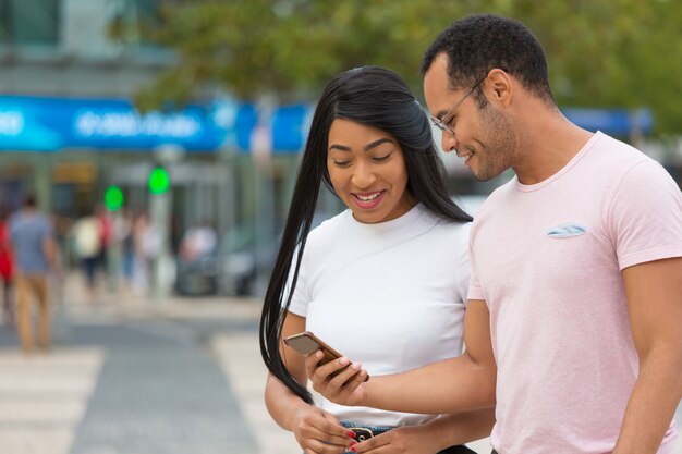 Vista frontale delle coppie felici che camminano sulla via e sulla conversazione