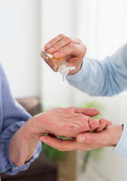 Vista frontale delle donne che usando disinfettante per le mani