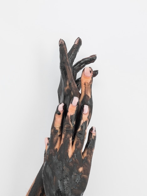 Vista frontale delle mani coperte di vernice nera