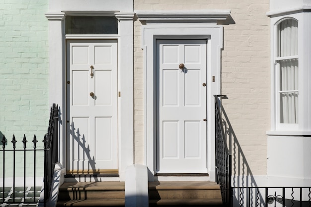 Vista frontale delle porte d'ingresso con parete verde e beige