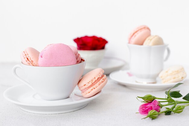Vista frontale delle tazze di macarons con rosa