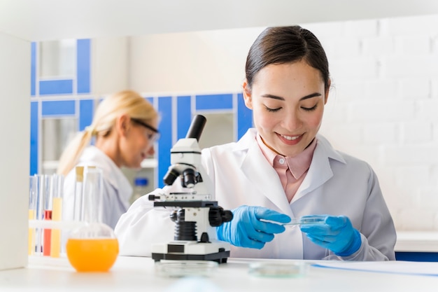 Vista frontale dello scienziato femminile di smiley in laboratorio