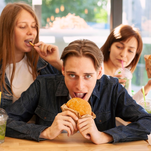 Vista frontale di amici che mangiano hamburger