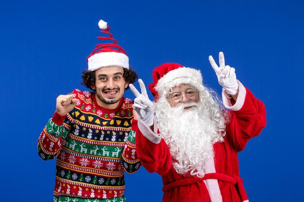 Vista frontale di babbo natale con il giovane sul muro blu